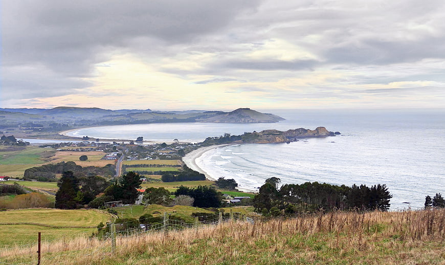 Scenic coastal landscape with ocean, beach, and rolling hills