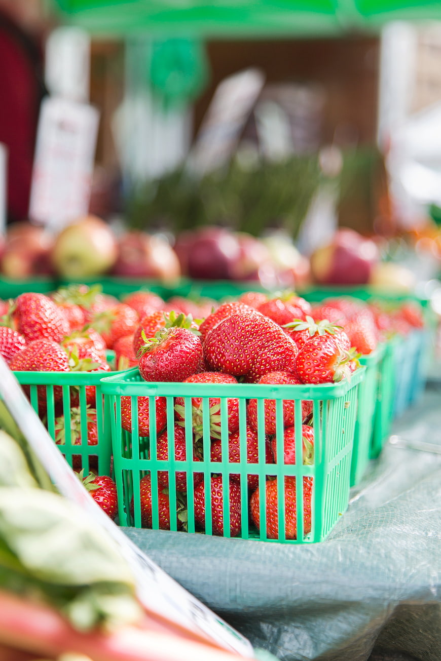 Fresh Strawberries in Green Baskets at Farmers Market