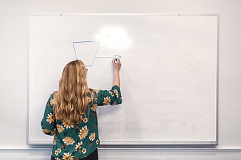 Woman drawing funnel diagram on whiteboard