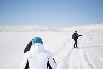 Winter Hikers on Snowy Trail with Blue Sky