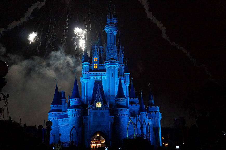 Disney Castle Illuminated in Blue with Fireworks at Night