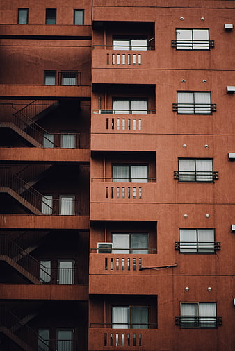 Red brick apartment building facade with repeating windows