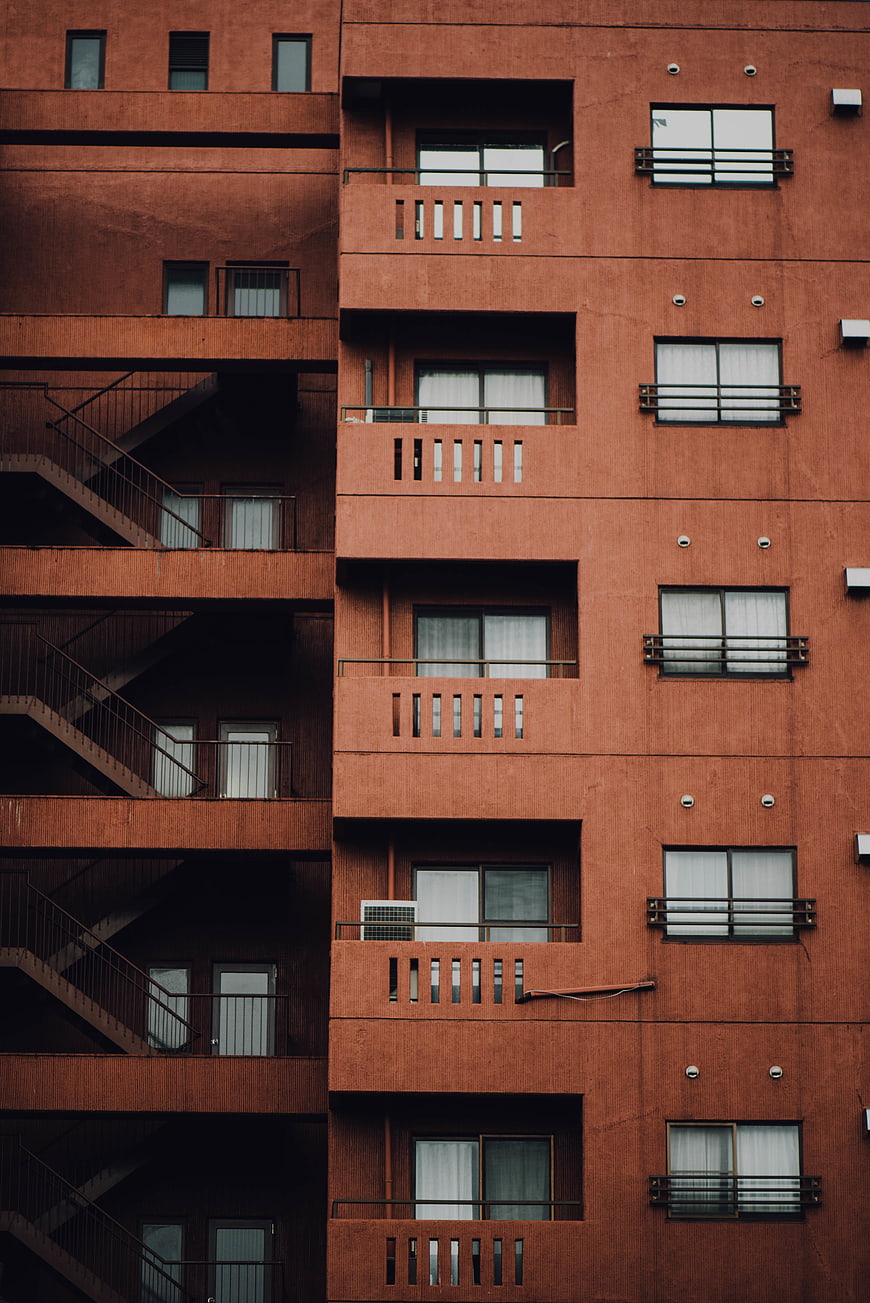 Red brick apartment building facade with repeating windows