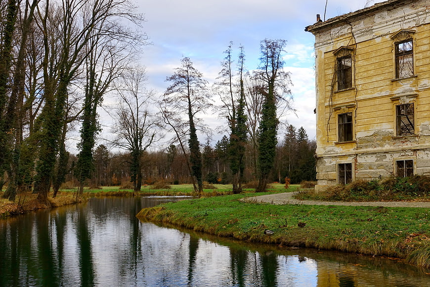 Abandoned yellow manor house by a river in autumn