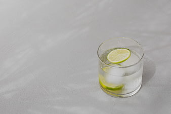 Refreshing Glass of Water with Lime and Ice on White Background