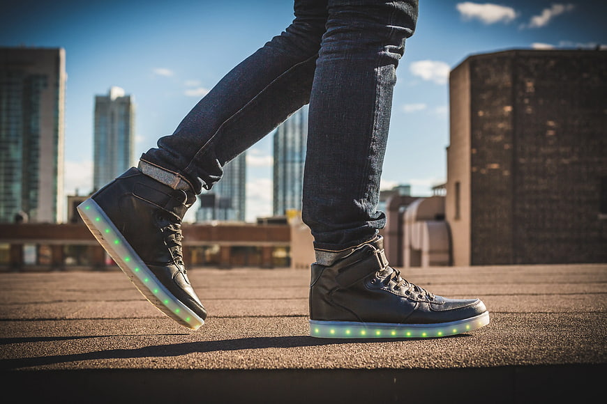 Man Wearing Black LED Light-Up Sneakers on Rooftop