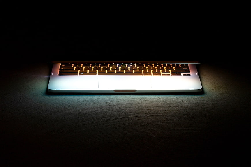 Illuminated Laptop Keyboard on Dark Surface