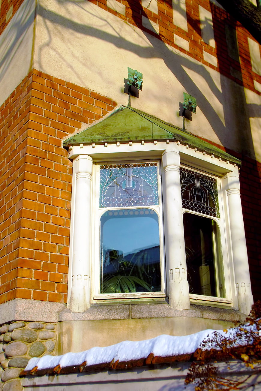 Art Nouveau window detail on brick building with snow