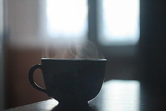 Silhouette of Steaming Coffee Cup on Table