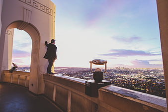 Man looking at city skyline from Griffith Observatory at dusk