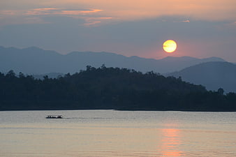 Sunset over Kaeng Krachan Lake with Distant Mountains and Small Boat