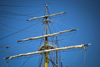 Tall ship mast and rigging against clear blue sky