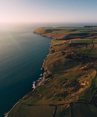 Aerial View of Dramatic Coastal Cliffs and Rolling Green Hills