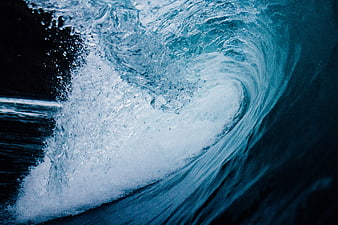 Dramatic close-up of a crashing ocean wave with blue water