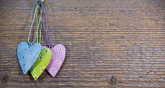 Colorful Heart Ornaments Hanging on Rustic Wooden Background