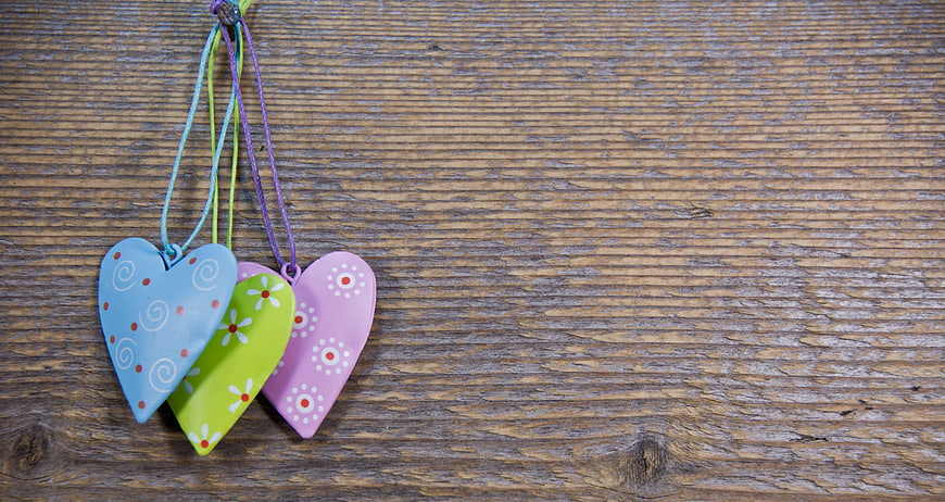 Colorful Heart Ornaments Hanging on Rustic Wooden Background