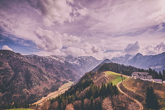 Scenic Alpine Mountain Landscape with Cloudy Sky and Rural House