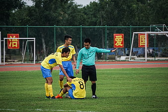 Soccer referee signaling to players on a football field