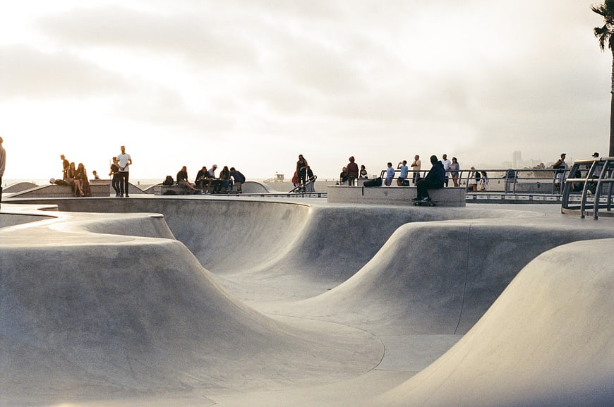 Concrete Skate Park with Skaters and Spectators