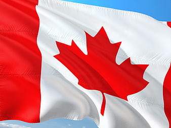 Close-Up of Waving Canadian Flag Against Blue Sky