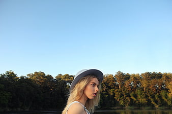 Blonde Woman in Hat Looking Away by Lake