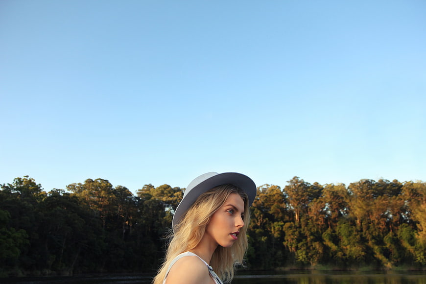 Blonde Woman in Hat Looking Away by Lake