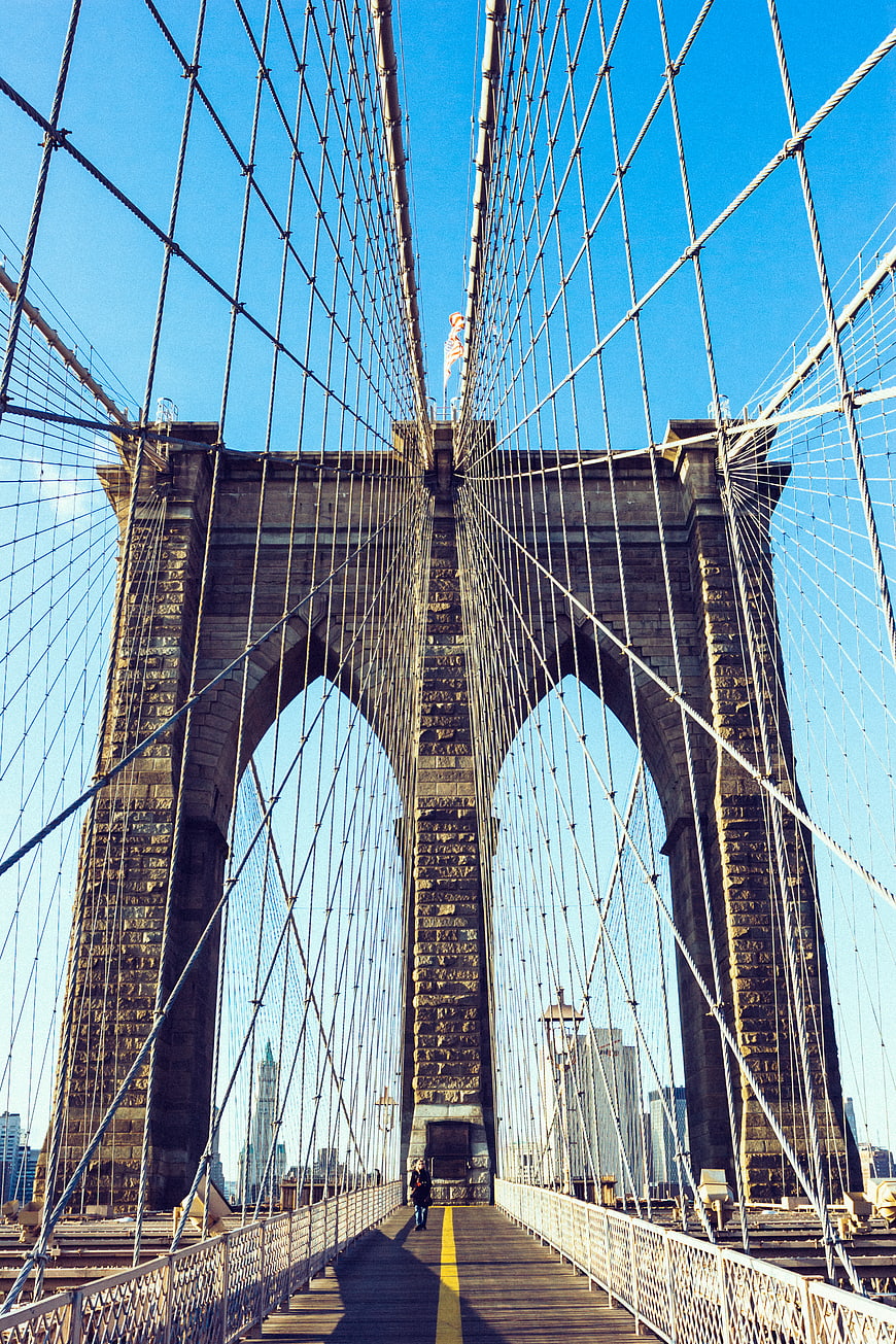 Low angle view of Brooklyn Bridge stone tower and cables