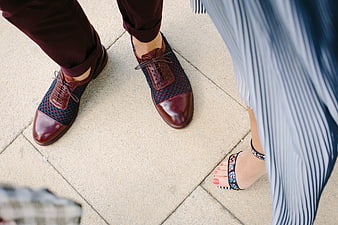 Couple's stylish shoes on pavement, fashion detail