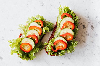 Top view of healthy open-faced vegetable sandwiches on marble
