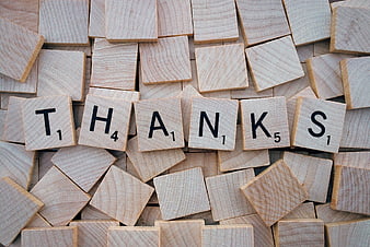 Wooden Scrabble Tiles Spelling Thanks on Pile