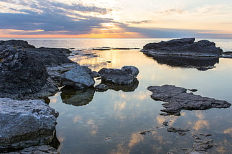 Serene Sunset Reflection on Rocky Coastal Tide Pools