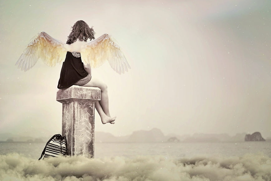 Woman with angel wings sitting on stone pillar in clouds