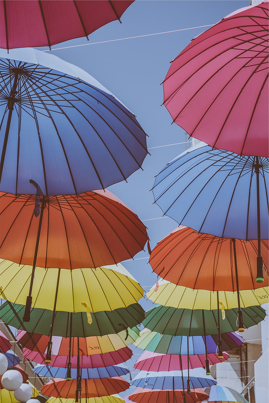 Colorful umbrellas hanging against blue sky