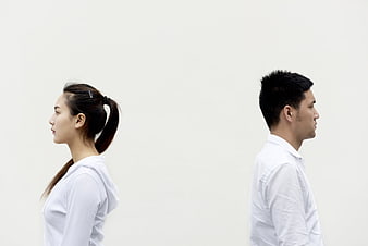 Man and woman standing back to back in white shirts