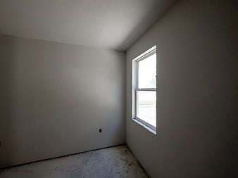 Empty unfinished room with window and concrete floor