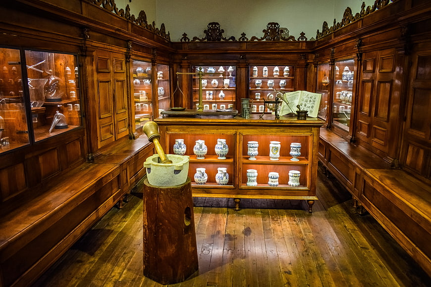 Historic Antique Pharmacy Interior With Wooden Cabinets And Ceramic Jars