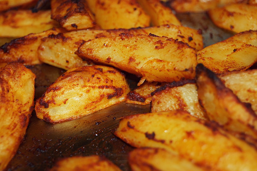 Close-up of roasted potato wedges with crispy edges