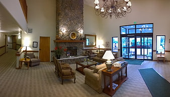 Spacious hotel lobby with stone fireplace and comfortable seating