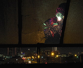 Fireworks Viewed Through Broken Window Over City Skyline