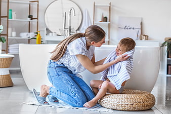 Happy Mother Drying Son with Towel in Modern Bathroom