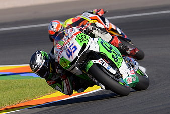 Motorcycle racers leaning into a sharp turn on a race track