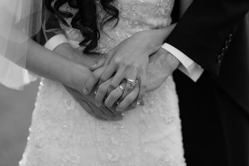 Close-up of wedding couple holding hands with rings