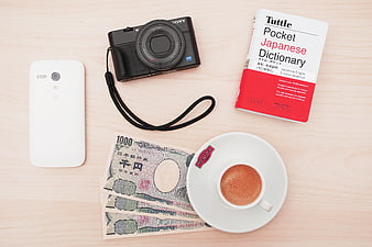 Flat lay of Japanese travel essentials with coffee and yen