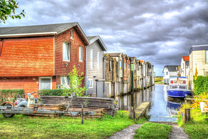 Colorful wooden houses along a canal with a blue boat