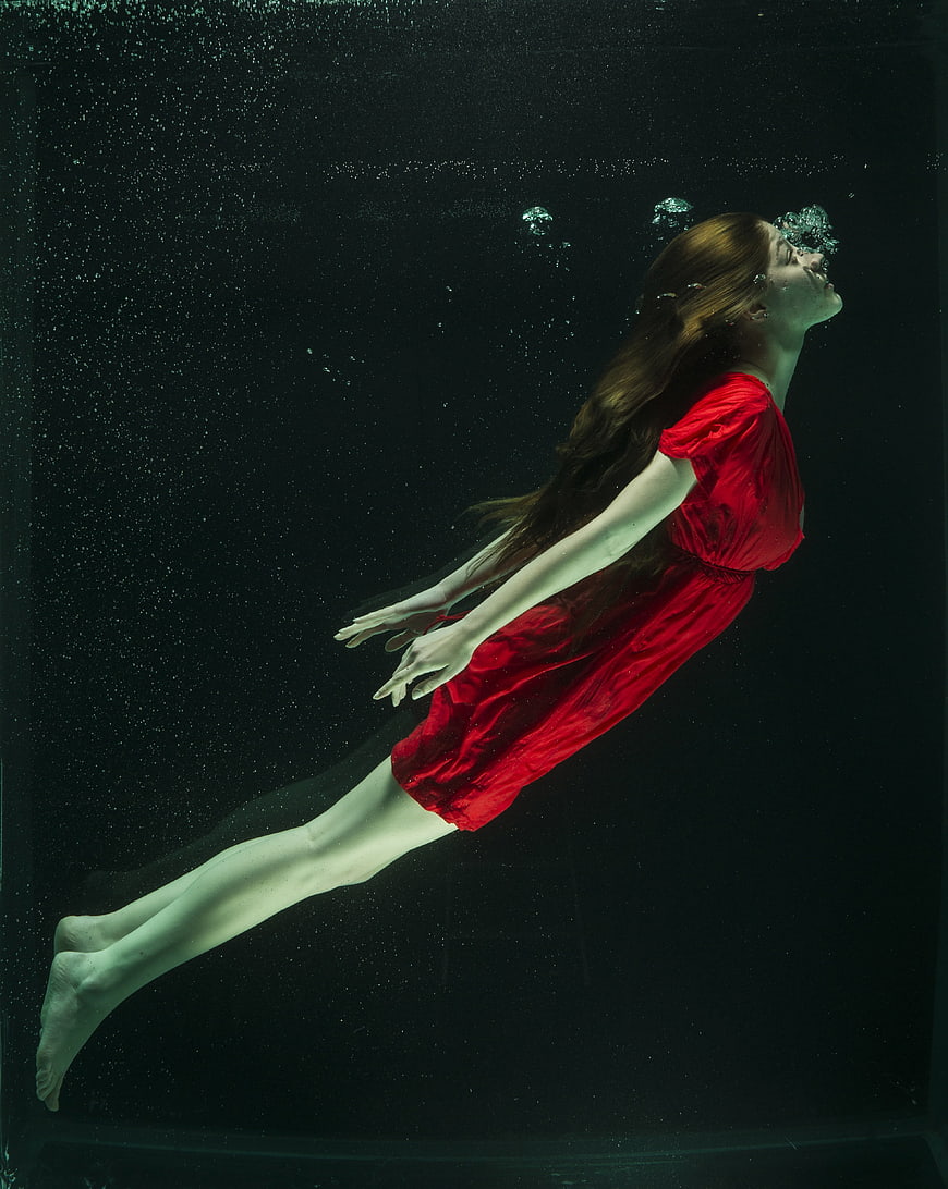Woman in Red Dress Floating Underwater