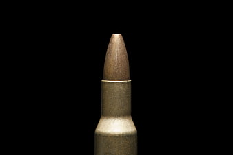 Close-up of brass bullet cartridge on black background