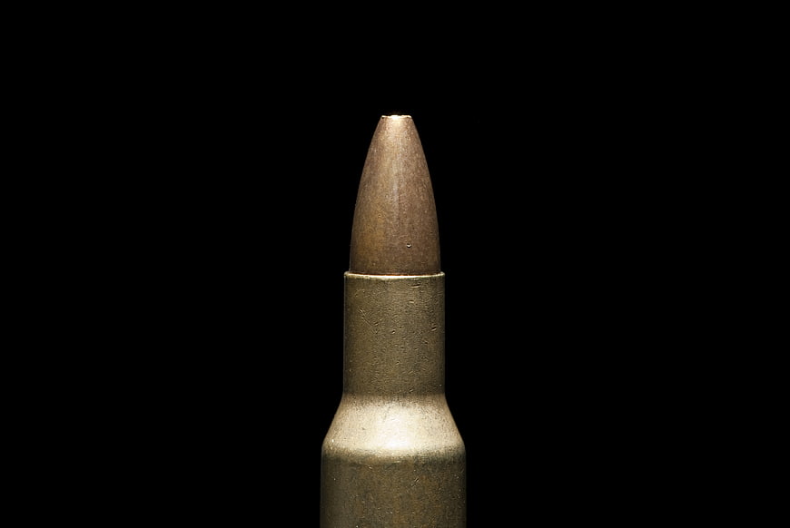 Close-up of brass bullet cartridge on black background