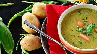 Bowl of creamy potato soup with carrots and wild garlic