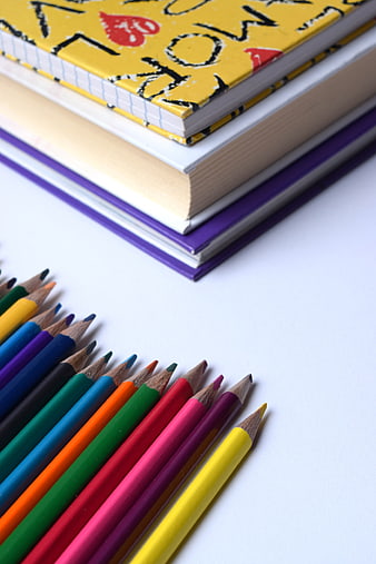 Colorful Colored Pencils and Stacked Notebooks on White Background
