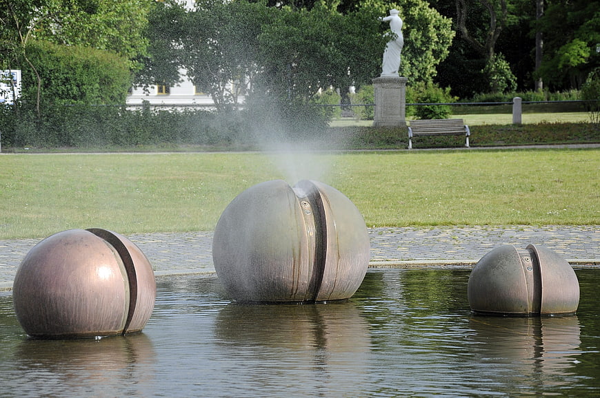 Modern spherical fountain sculptures in a park pond